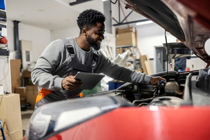 An auto mechanic is inspecting engine performance during diagnostics