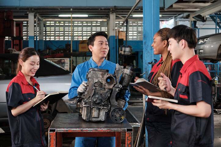 An automotive instructor explaining powertrain operation to future technicians