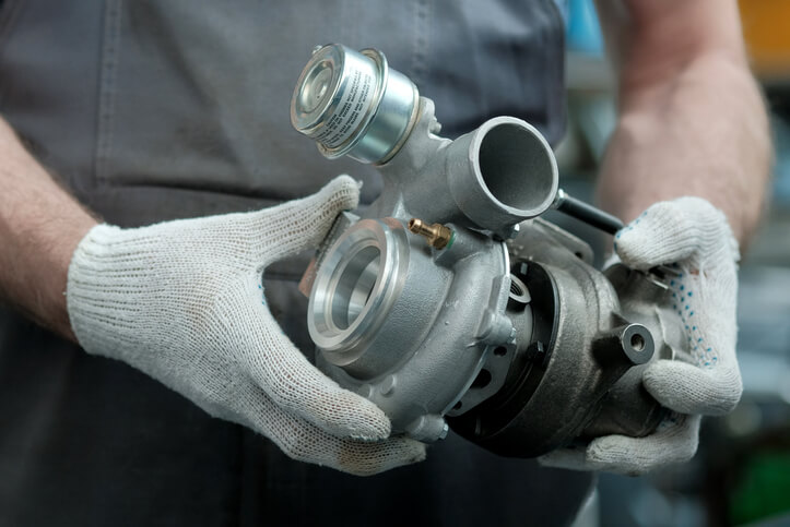 A technician inspecting turbocharger components on a modern engine