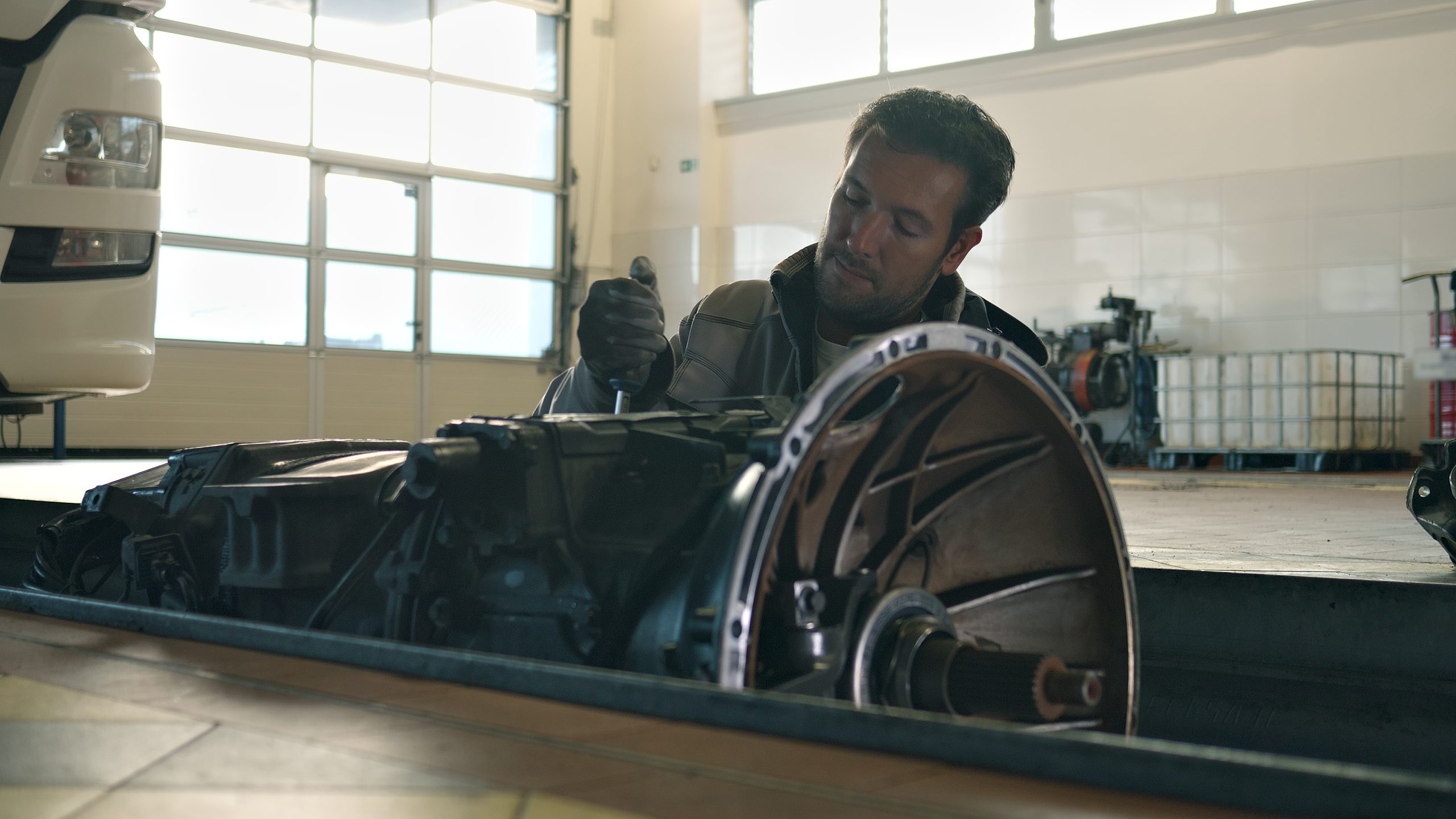 An automotive student examining a vehicle transmission during hands-on training