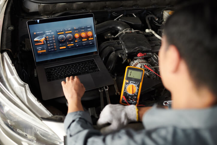A technician diagnosing engine fault codes through the powertrain control module