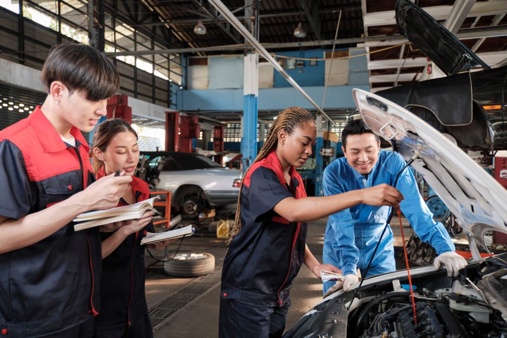 A student learning high-voltage safety during hybrid vehicle training