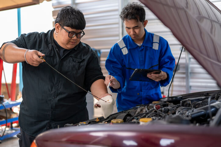 An automotive student identifying different transmission fluid types during hands-on training
