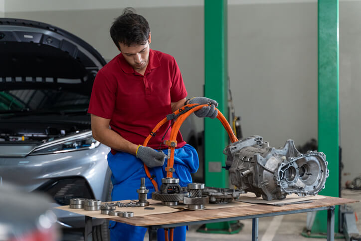 Technician servicing a hybrid transaxle in an automotive workshop