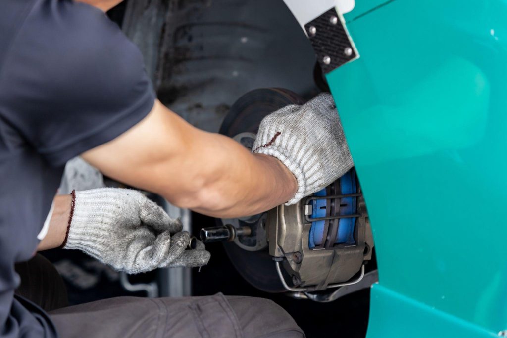 Technician performing rear brake service on an electric vehicle