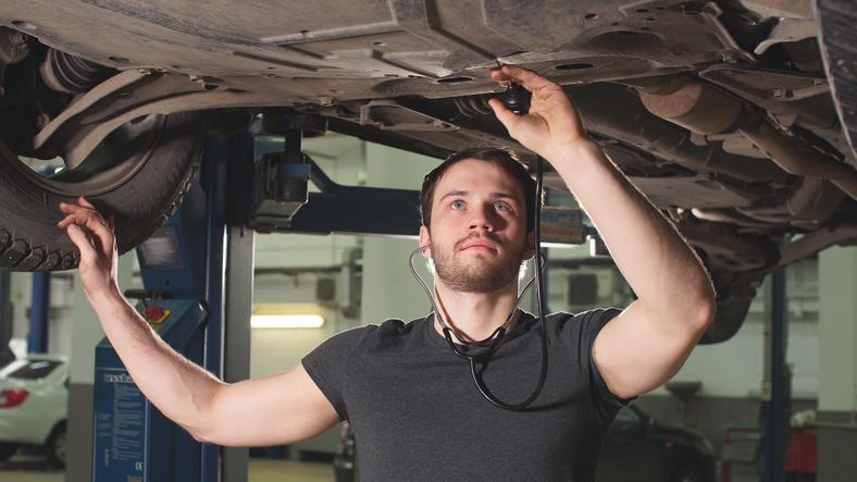 A technician diagnosing clicking noise when turning a vehicle