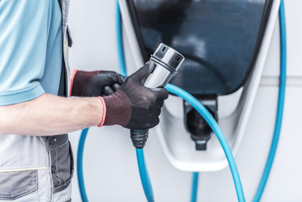 Technician preparing an electric vehicle for DC fast charging