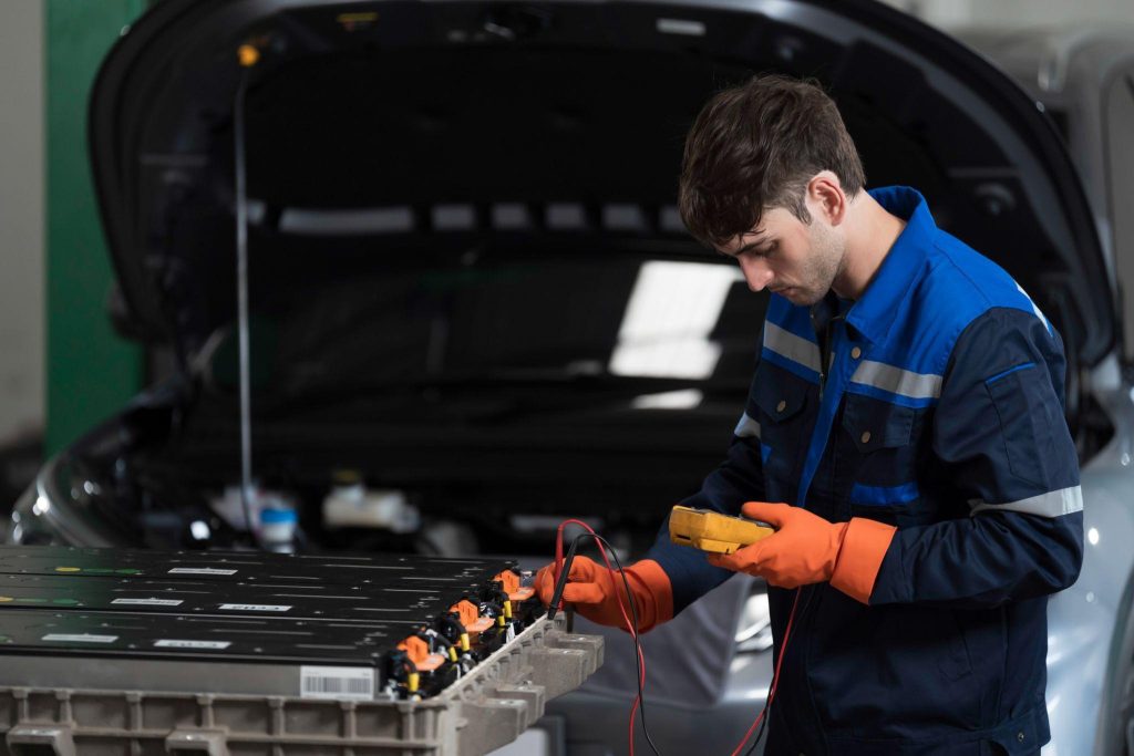 Technician inspecting the high-voltage battery in a plug-in hybrid vehicle