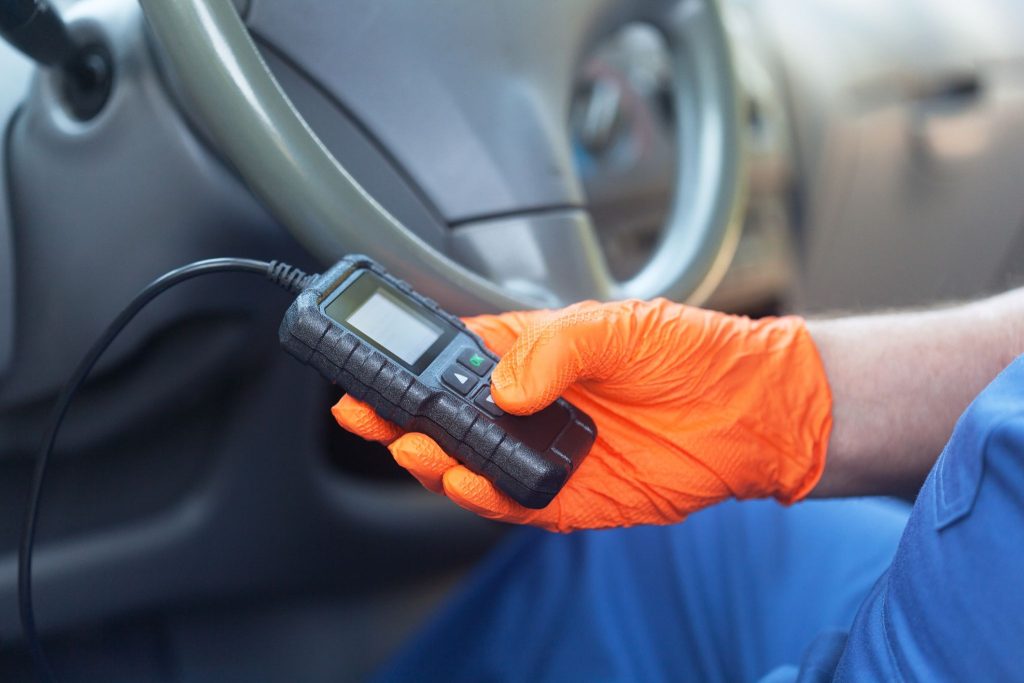 A technician using an OBD2 scanner to read fuel trim data
