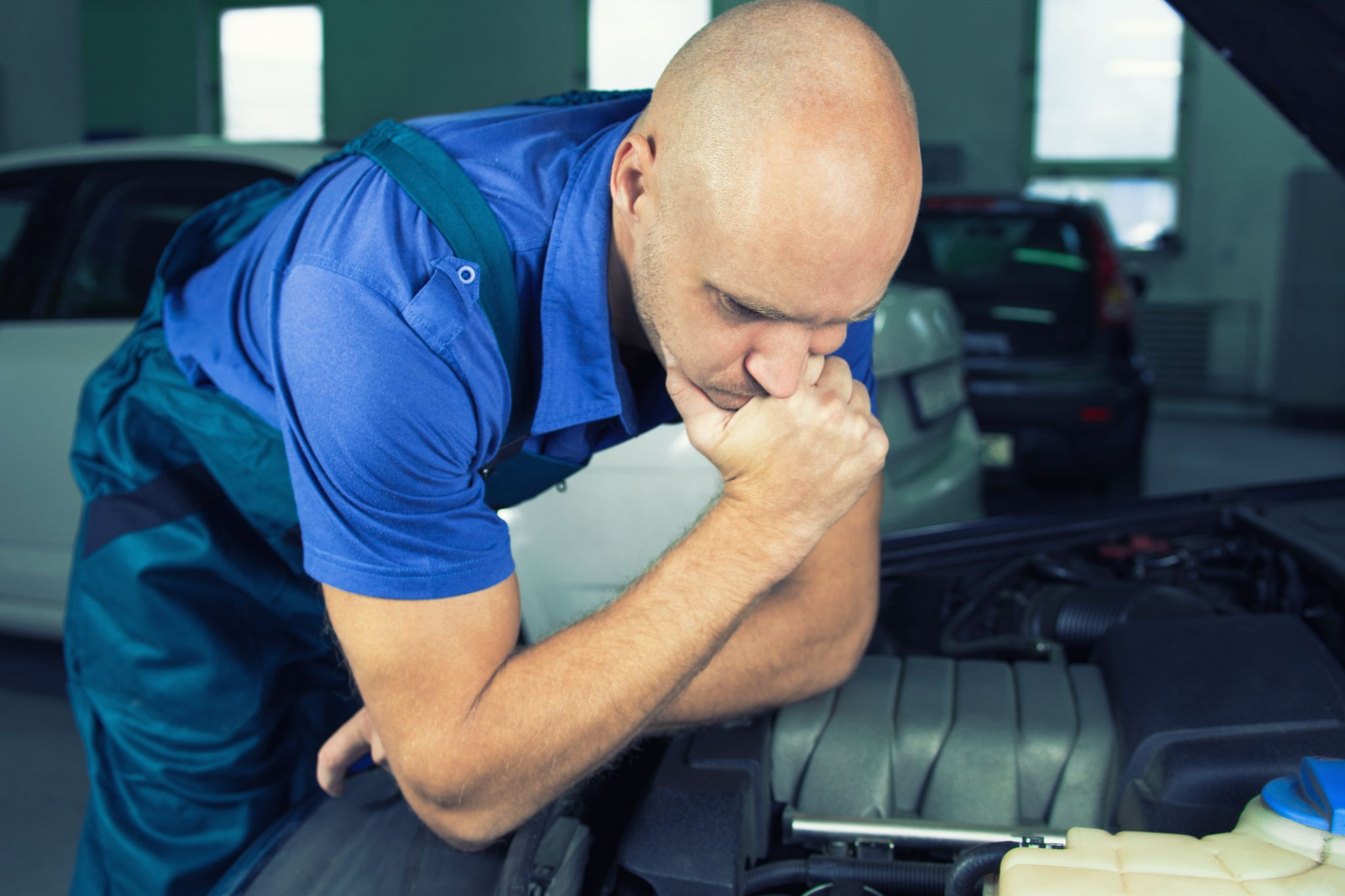 Technician checking bad PCV valve symptoms during engine diagnosis