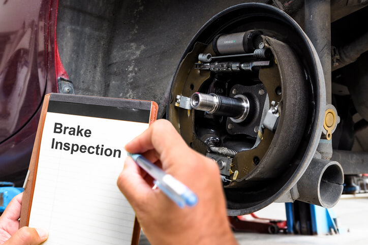 A technician inspecting a vehicle's braking system