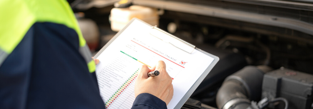 An automotive student reviewing a car inspection report