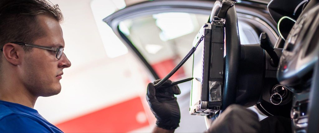 A technician performing EVAP system diagnostics in an automotive workshop
