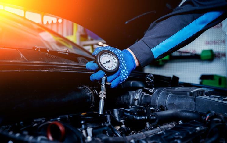 A future technician performing a fuel pressure test on a vehicle