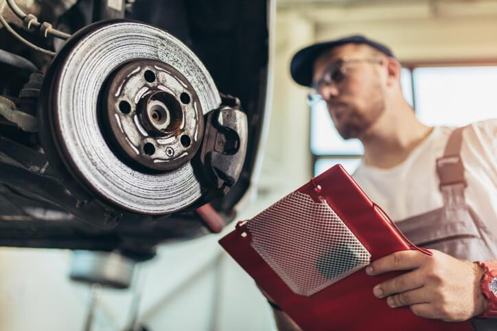 A technician inspecting a car brake system after a hard pedal complaint