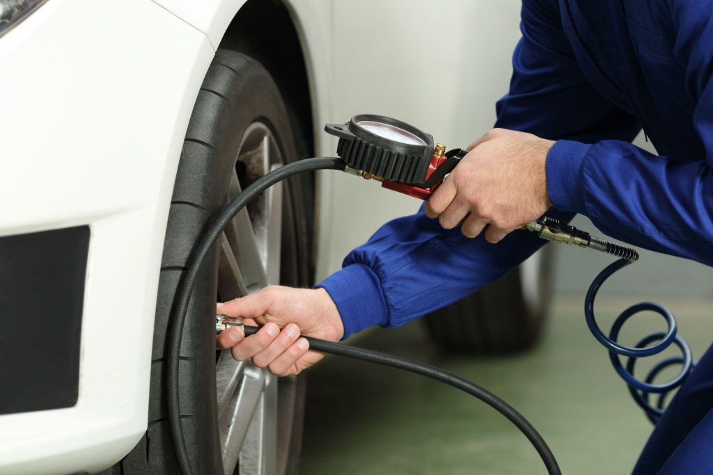 Automotive student inspecting tires during vehicle maintenance