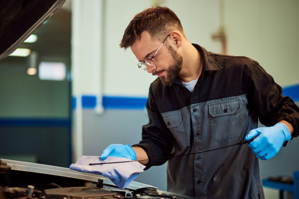 A technician checking engine oil condition during timing chain diagnosis