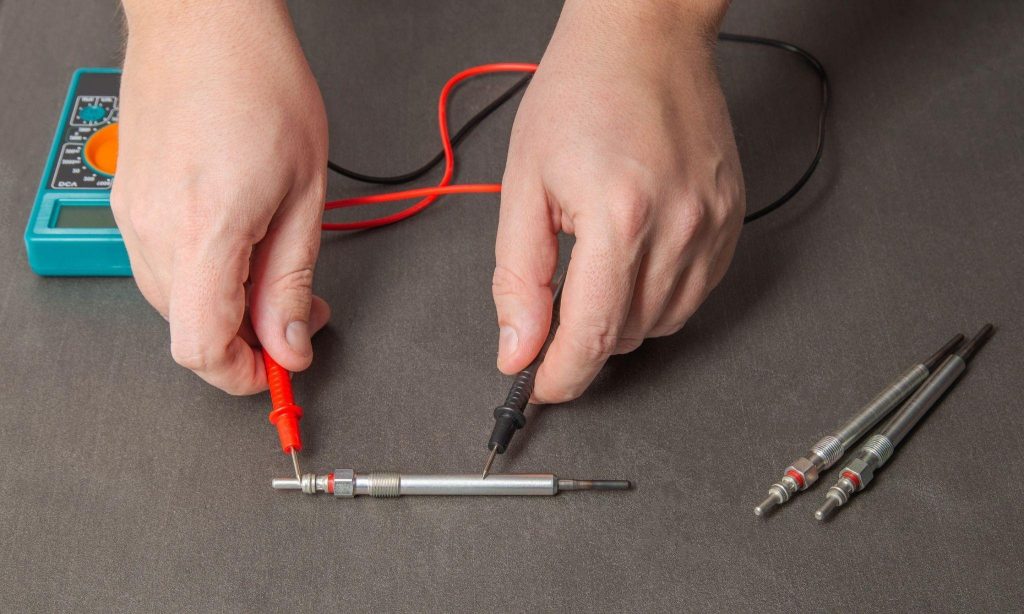 An automotive student checking a diesel glow-plug electrical circuit