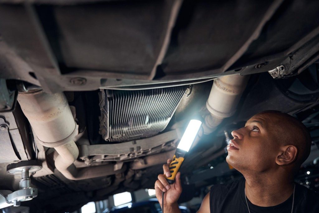 A mechanic inspecting a cooling system after a suspected heater core leak