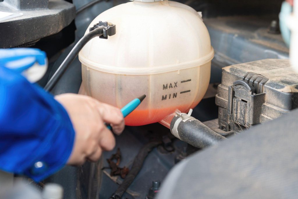 A technician checking coolant level during heater system diagnosis