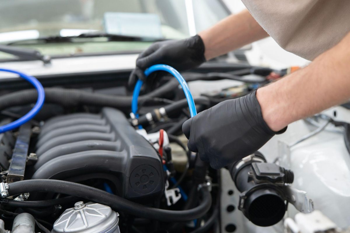 An automotive student testing a purge valve during EVAP-system diagnosis