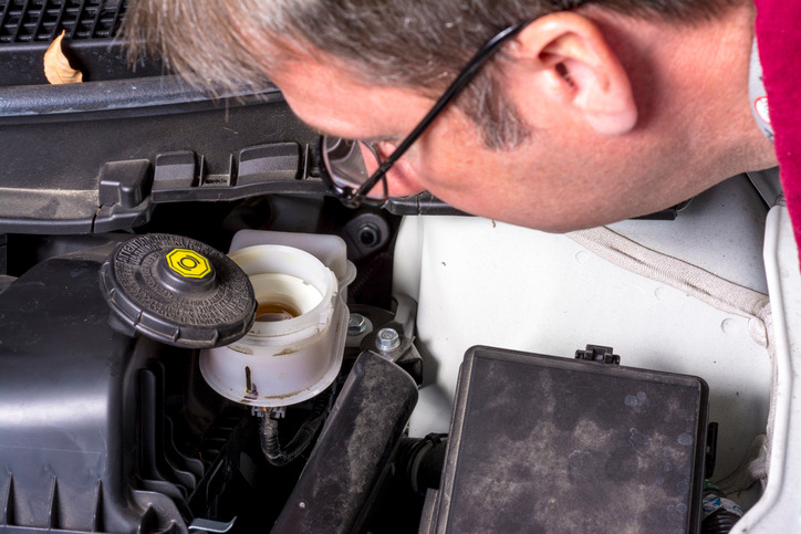 Technician testing a sinking brake pedal for master-cylinder internal bypass