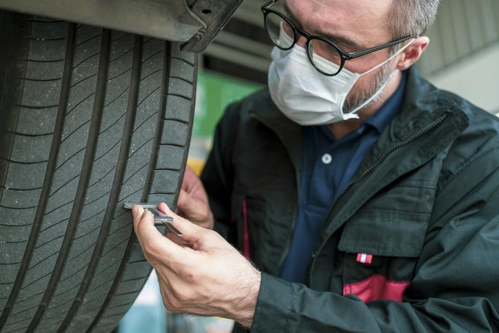 A Montreal technician measuring tire tread depth before wet fall weather