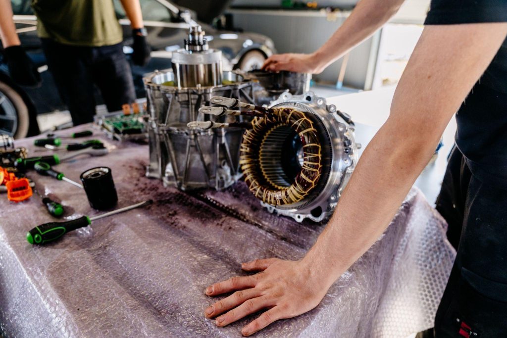 A student examining an electric car gearbox during EV drivetrain training