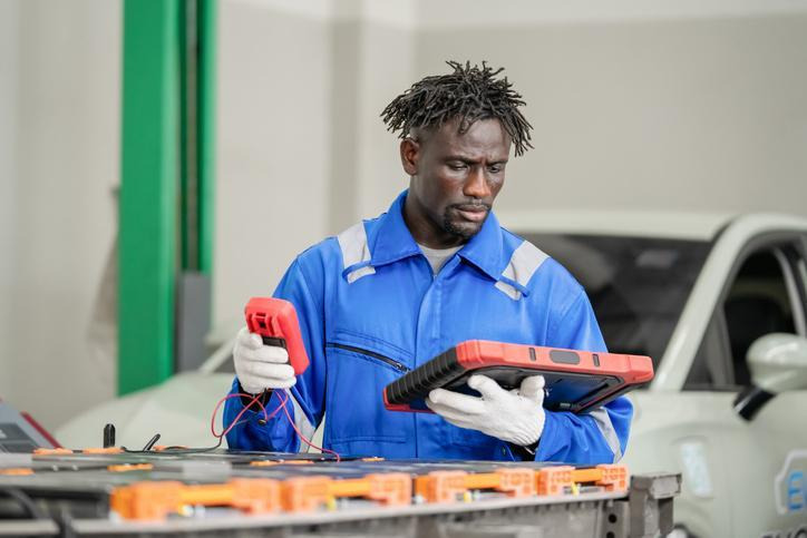 A technician inspecting vehicle electrical circuits using diagnostic equipment