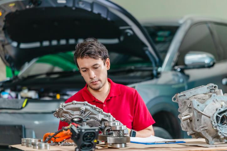 A student examining components of an electric car heating system