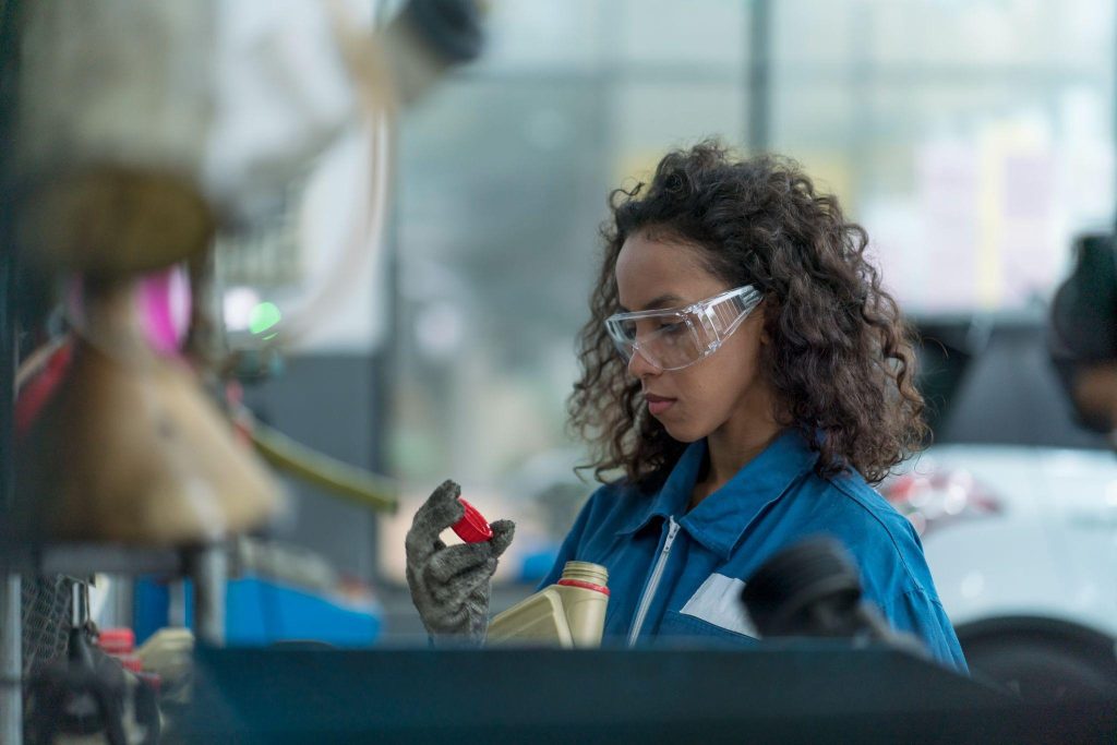 A student checking EV reduction-gear fluid during automotive training