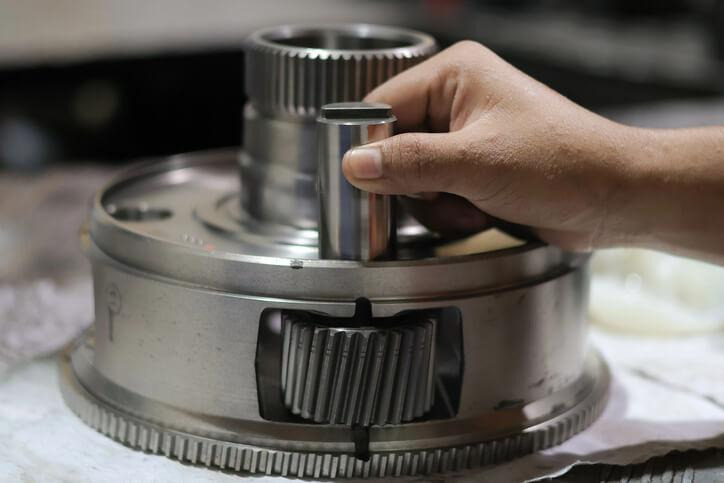 An automotive student studying planetary gears of a vehicle