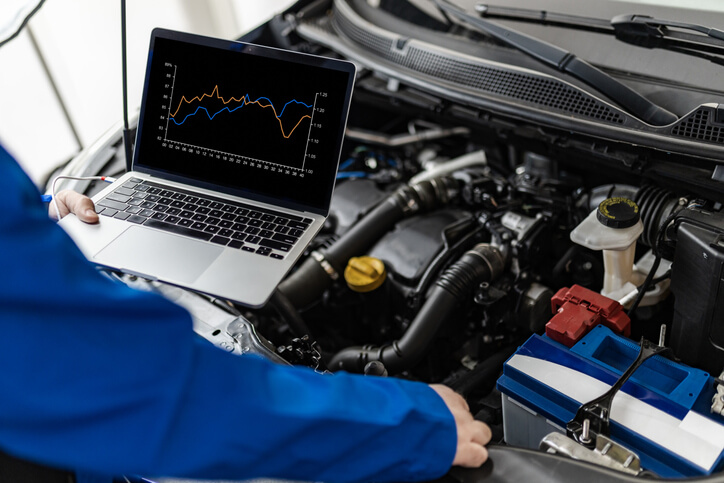 An automotive student comparing intake pressure readings during engine diagnosis