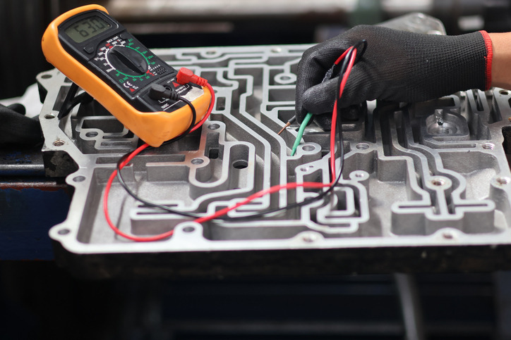 Automotive student examining transmission wiring during practical diagnostic training