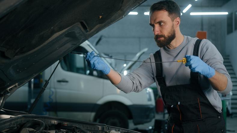 A technician inspecting engine oil after repeated short winter trips